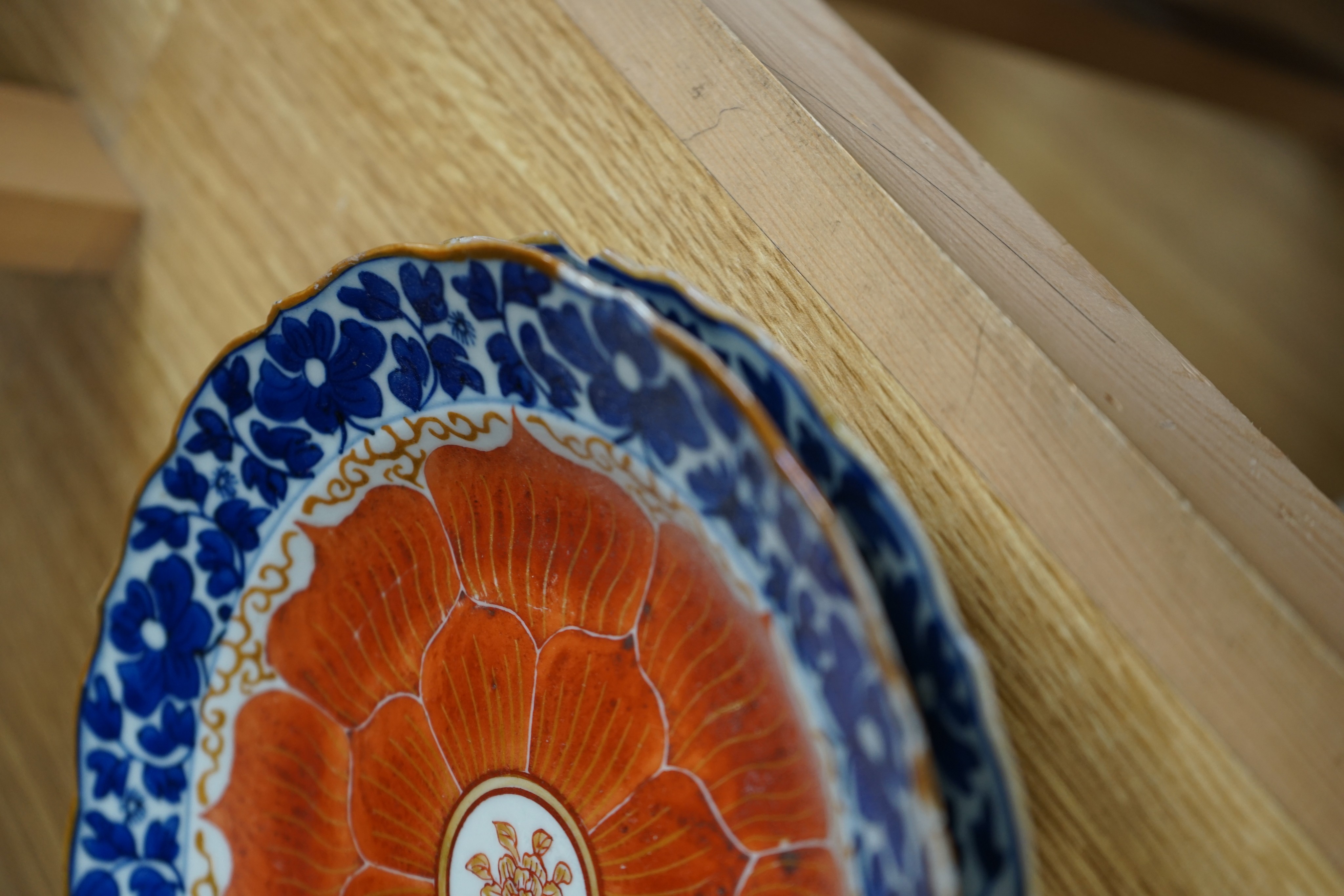 A set of eight Chinese plates with orange 'lotus' centres and blue floral borders, Qing dynasty, Dia 20cm
